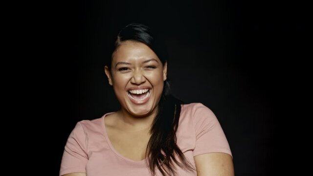 Close up of a young female making funny faces on black background. Close up of a woman doing funny facial expressions.
