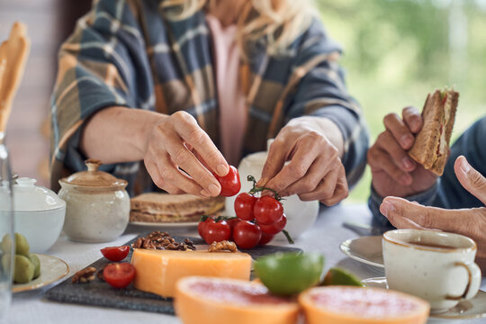 Mature man and woman having breakfast outdoors - Powered by Adobe