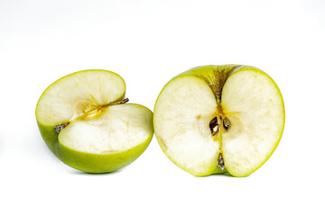 Fresh green apples cut in half on a white background