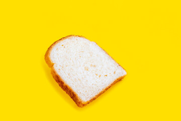 Close up photo of fresh baked toast bread on yellow background. Top view. Bread for breakfast.