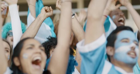Crowd of soccer fans from Argentina cheering their team with a blue garlands and argentinian flags at stadium. Football fans sitting at stadium starts cheering when their national team scores a goal.
