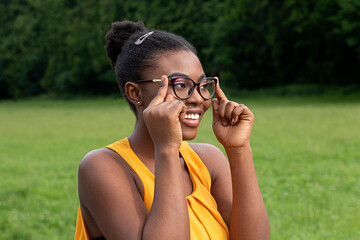 Outdoor Portrait Of Excited Young Female Wearing Glasses And Looking Into The Camera Whiles Smiling