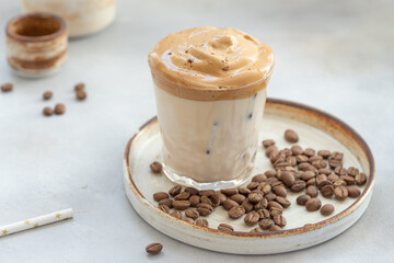 whipped Dalgona coffee in a glass on a gray background. Trend korean iced latte. close-up. horizontal image. place for text.