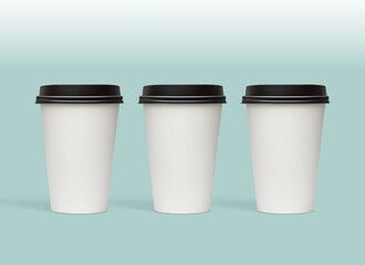 White blank small size takeaway paper, carton or cardboard coffee cups with black caps packaging template mockup isolated on light green background  