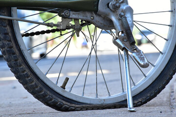 Closeup view of bicycle flat tire on pavement.