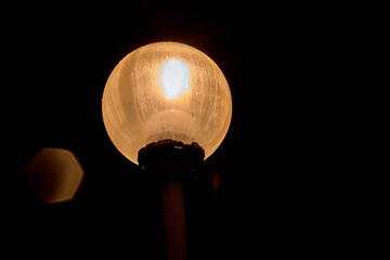 glowing round a lamppost in the night sky next to the glowing moths