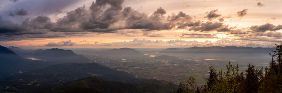 Beautiful Panoramic View of Fraser Valley during a colorful cloudy sunset. Taken from Elk Mountain in Chilliwack, East of Vancouver, British Columbia, Canada. Nature Landscape Panorama Background