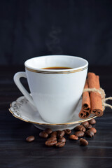 A Cup of fragrant coffee and cinnamon on a black background.