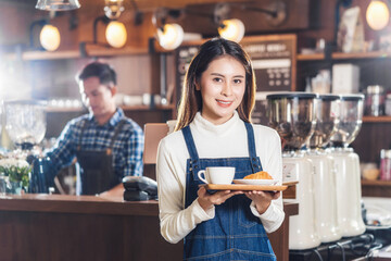 Asian Coffee shop owner serving bakery cake and coffee cup to customer in coffee shop, Small...