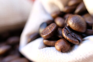 close up coffee beans and coffee cup on wood table background and texture