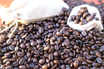 close up coffee beans and coffee cup on wood table background and texture