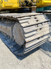 Excavator track pad and grouser pad with top carrier rollers in dirt in close up