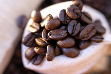 close up coffee beans and coffee cup on wood table background and texture