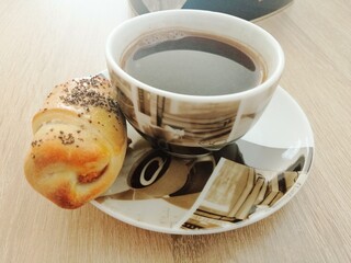 cup of black coffee and homemade croissant, close up