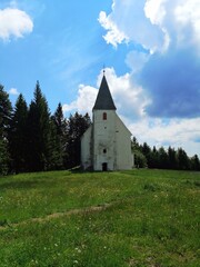church on the Areh, Slovenia, green meadow with forest