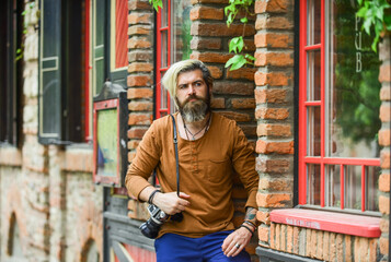 waiting for you. bearded man hipster take photo. photo shooting outdoor. brutal man traveler with retro camera. photography in modern life. travel tips. professional photographer use vintage camera