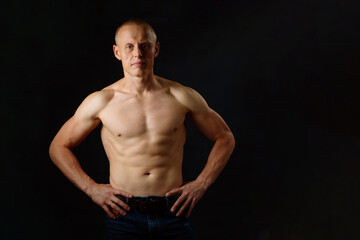 Fototapeta premium Strong Athletic Man Fitness Model. Isolated On Black Background With Copy Space