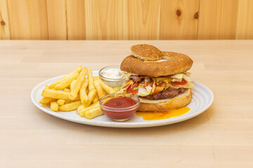 Burger with potatoes on wooden background