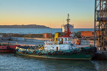 Ships in a cargo seaport at sunset.