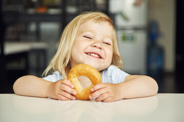 portrait of a funny little girl with bagel. child playing at home. - 359257318