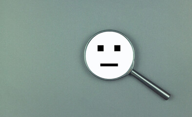 Neutral smile icon on a magnifying glass.