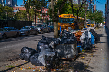 Street in the center of New York with trash near a school bus