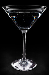Martini glass with drink on black background