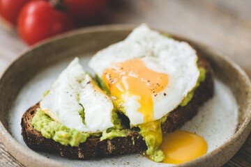 Toast with avocado and fried egg on plate. Healthy breakfast lunch or snack food