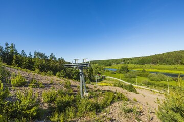 Fototapeta na wymiar Slalom ski lift on hill peak on blue sky background. Beautiful landscape view on summer day. Sweden.