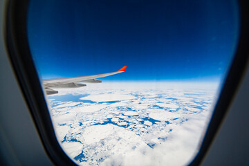 Amazing view of the glaciers and ocean from the porthole when flying over Greenland