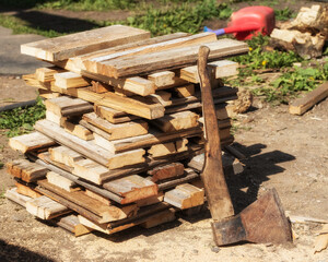 Stacked in a log of wood, next to an axe.