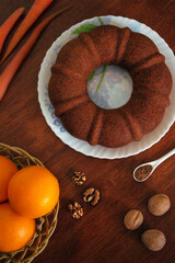 Homemade carrot cake with walnut and cinnamon on wooden background