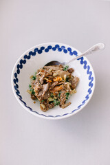 Pearl barley porridge with spinach and roast turkey with dried apricots in a deep plate. Healthy food for lunch or dinner