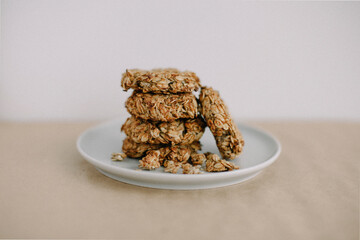Homemade oatmeal cookies on small plate and light background.