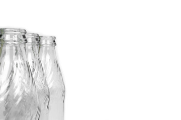 Empty bottles on white background with copy space. Standing close-up empty bottles with copy space. Front part prominent, rear part blurred glass bottles.