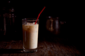 Milkshake with a red tube on a dark background.With copy space
