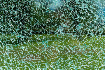 Gesprungenes Glas mit Wiese im Hintergrund