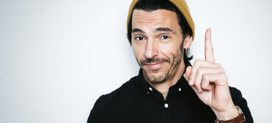 Portrait of a handsome guy pointing finger up