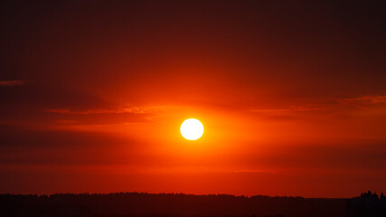 Beautiful red sun over the city at sunset.