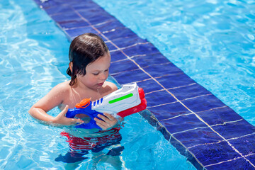 Kid boy playing in the swimming pool. Childhood, summer and vacation concept