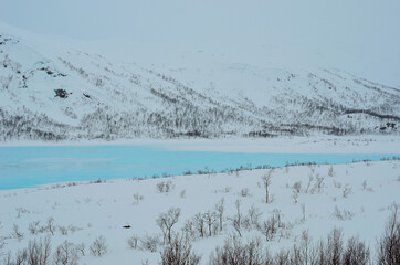 vibrant blue mountain lake ice in winter landscape
