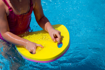 Kid girl playing in the swimming pool. Childhood, summer and vacation concept