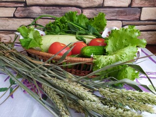 Still life in the kitchen vegetables zucchini cucumbers tomatoes onion salad fruit yellow pear on the table near the brick wall