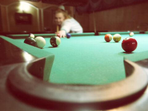 People Play Billiards, Billiard Balls On The Table In The Interior Of The Billiard Game Hall Interior. Abstract Blurred Vintage Image.