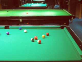 billiards, billiard balls on the table in the interior of the billiard game hall interior. Abstract blurred vintage image.