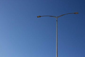 Fototapeta na wymiar Street light against the blue sky with clouds. Copy space.