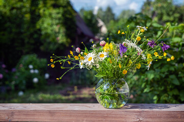 A bouquet of wild flowers in a glass vase.