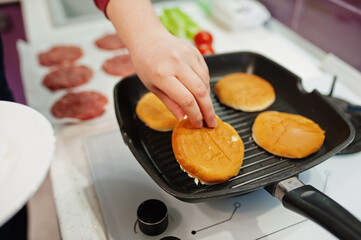Сooking burgers in the kitchen at home during quarantine time.