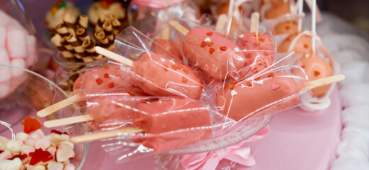 Lots of pink cakes in transparent glossy packaging on a plate