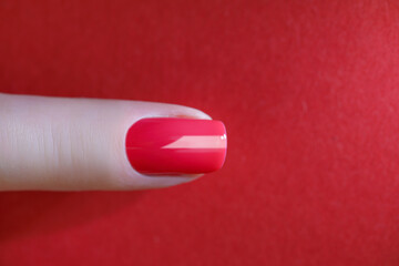 Red Finger nail point isolated red background with nail polish. Painting nails.